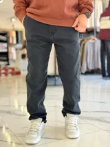 Pantalón de jean gris oscuro, de corte recto y estilo relaxed fit, con costuras reforzadas decorativas en las piernas.