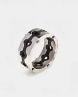 Anillo de acero italiano con diseño de banda ancha y calados en forma de trébol con fondo negro.