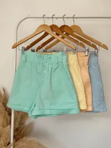 Short amarillo con cintura elastizada, lazo para atar y botones decorativos.