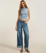 Top sin mangas negro, ajustado al cuerpo, con cuello alto y sutiles drapeados laterales.