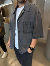 Camisa de jean con lavado gris, corte boxy, manga corta, cuello clásico y bolsillo frontal en el pecho.