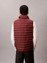 Chaleco acolchado tipo puffer Calvin Klein, con cuello alto y cierre frontal con cremallera. Diseño sin mangas confeccionado en nailon reprocesado.