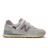Championes New Balance modelo 574 con tecnología Cordura, confeccionados en ante y malla en tono gris con detalles en lila y suela de goma color caramelo.
