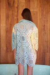 Camisa corta de género calado texturizado, con cuello solapa, abotonada y de corte clásico holgado.