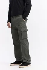 Pantalón cargo de corte baggy, color beige, con bolsillos laterales tipo cargo con cierre y solapa, y diseño de pierna ancha.