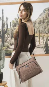 Bandolera de diseño práctico y moderno, confeccionada en tela impermeable color verde militar. Presenta un bolsillo frontal con diseño capitoneado geométrico, cierre principal y bolsillo trasero con cierre. Incluye correa ajustable y detalles en negro.