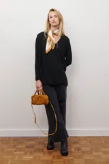 Sweater de tejido de punto color beige, con escote en V y mangas largas. Presenta un diseño básico y versátil de corte recto.