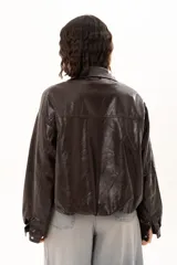 Campera de cuero sintético color chocolate, con cierre frontal, cuello camisero y diseño holgado.