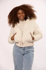Campera bomber de nylon color rosado, con diseño acolchado, cierre frontal con cremallera y botones a presión, y capucha con borde de piel sintética al tono.