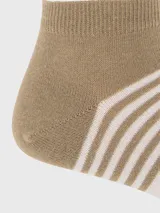 Calcetín deportivo tipo soquete con diseño tricolor en bloques de color beige, blanco y turquesa, con detalle de rayas horizontales y logo de la marca en el empeine.