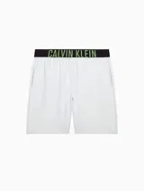 Short de dormir blanco de corte holgado, con cintura elástica negra que lleva el logo de Calvin Klein en verde neón.