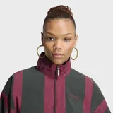 Campera deportiva Adidas modelo Blocking de corte holgado, en color bordó con paneles grises en la parte superior y mangas. Cuenta con cuello alto, cierre frontal completo y bolsillos laterales.