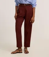 Pantalón carrot de cintura alta y corte zanahoria, color bordó, confeccionado en viscolino con pliegues en el frente y trabillas. Incluye cinturón fino de poliuretano con hebilla.