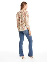 Blusa de gasa con estampado floral y de mariposas, color beige. Presenta cuello a la base fruncido, escote en V con aplique de puntilla vertical en la parte delantera y cierre central con botones forrados. Posee mangas tres cuartos con puños abotonados.
