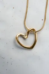 Collar dorado con dije de corazón calado.