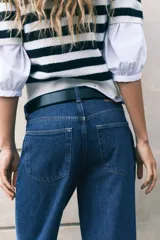 Jeans de cinco bolsillos en denim de algodón lavado, color azul medio. Modelo de tiro alto con piernas rectas de corte holgado y cierre con botón.