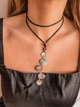 Collar con tiento negro y dije plateado con forma de círculos unidos.