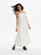 Vestido largo color blanco hueso, con breteles finos, escote recto y cuerpo fruncido.