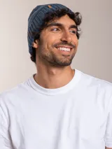 Gorro de lana azul con etiqueta de cuero sintético con logo de la marca en el frente.