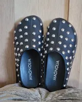 Zuecos negros de cuero vegano con tachas plateadas.