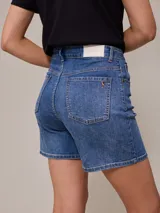 Short de jean elastizado en color azul claro, de tiro alto con cierre y botón metálico, diseño clásico de cinco bolsillos con costuras a contratono.