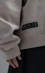 Buzo de cuello redondo confeccionado en frisa de algodón, con diseño de hombros caídos y calce regular. Presenta un bordado del logo en el frente y terminaciones en punto rib en cuello, puños y ruedo.