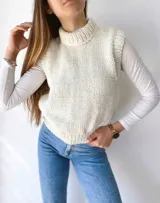 Chaleco tejido a mano color beige con cuello alto y sisas amplias.