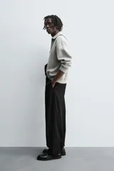 Polo de punto de corte relajado, confeccionado en mezcla de algodón, con cuello solapa, cierre frontal de cremallera y manga larga con acabados en rib.