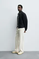 Cazadora cropped fit color azul marino, confeccionada en tejido de algodón. Presenta cuello solapa, manga larga con puño abotonado, bolsillos frontales de vivo y un bolsillo interior. El cierre es frontal con cremallera.