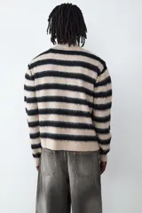 Cardigan de punto con diseño a rayas horizontales en tonos beige y negro, cuello en pico y cierre frontal con botones.