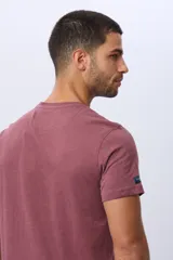 Remera básica de manga corta con cuello redondo, confeccionada en tejido de algodón. Presenta un pequeño logo bordado en el pecho.
