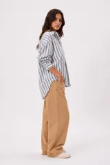 Camisa de manga larga con diseño de rayas verticales en tonos azul, blanco y beige, cuello camisero y cierre frontal de botones.