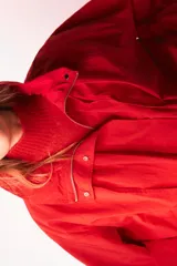 Chaleco de punto sin mangas, color rojo, con cuello subido y diseño de tejido texturizado.