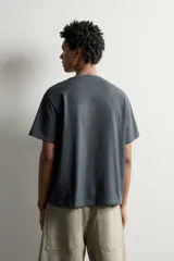 Camiseta relaxed fit de manga corta y cuello redondo, color gris oscuro, con estampado en relieve tono sobre tono con la palabra 'MODULE' en el frente.