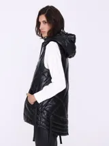 Chaleco negro charolado con capucha y cierre frontal.