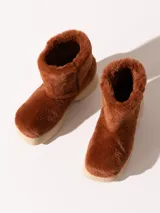 Bota de media caña color marrón, realizada en pelo sintético con detalles en cuero vacuno y suela de eva. El interior está forrado en cuero vacuno.