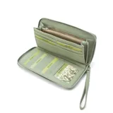 Billetera larga con cierre perimetral, confeccionada en material sintético texturizado color mostaza. Cuenta con correa de mano extraíble y placa metálica con logo de la marca en el frente.