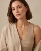 Collar de bronce con cadena fina y dije en forma de mano con gestos.
