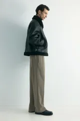 Pantalón de corte relajado y pierna recta, confeccionado en tejido suave de color marrón. Presenta cintura elástica con cordón de ajuste, pliegues frontales y traseros, bolsillos laterales y un bolsillo posterior insertado.