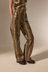 Pantalon de corte recto con diseño de estampado de piel de serpiente, confeccionado en cuero sintético (PU). Presenta bolsillos laterales y cierre frontal con botón.