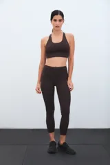 Calza deportiva de tiro alto color marrón, con diseño de perforaciones láser en la parte inferior de las piernas.