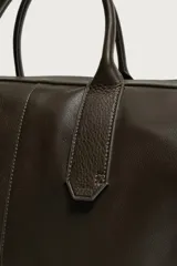 Bolso shopper de hombro fabricado en piel con acabado abatanado. Cuenta con compartimento principal con cierre de cremallera, interior con bolsillo plano y bolsillo con cierre. Incluye dos asas de mano, asa de hombro y detalle de llavero colgante.