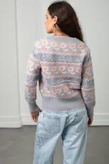 Cárdigan tejido de punto en color gris, con diseño estampado de flores y guardas caladas. Presenta escote en V, cierre frontal con botones y terminaciones acanaladas en puños y ruedo.