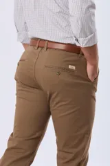 Pantalón de gabardina azul marino de corte slim fit y tiro medio, con bolsillos traseros ojalados con botón y presillas para cinturón.