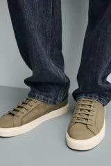 Zapatilla de cordones color negro con parte superior lisa, horma redonda y forro interior a contraste. Suela de goma color crema con ligera textura y detalle en el talón color crema.