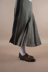Falda midi gris con diseño de espiga, corte evasé y abertura frontal.
