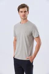 Remera lisa de manga corta y cuello redondo, color gris oscuro, de calce cómodo con pequeño logo bordado en el pecho.