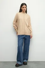 Polera negra de manga larga con puños elastizados, cuello alto y sutiles aberturas en los laterales.
