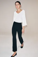 Pantalón de tiro alto con diseño cropped, confeccionado en tejido con viscosa. Presenta raya planchada frontal, aberturas laterales en el bajo y cierre lateral con cremallera oculta.