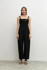 Mono negro de corte palazzo, con breteles finos y escote recto con detalle de smock.